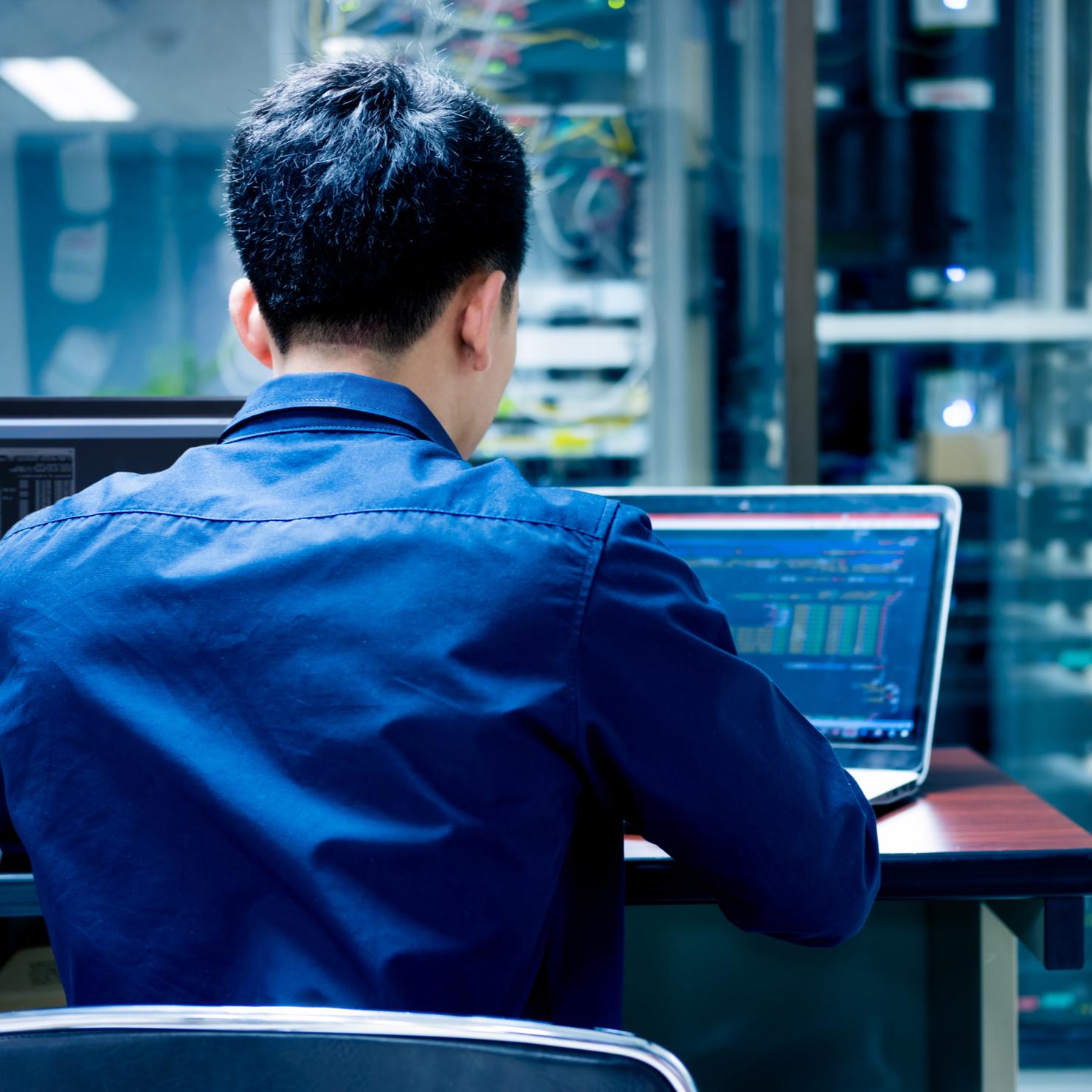 man on laptop providing network maintenance services